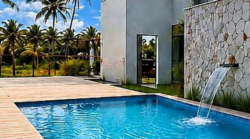 Private pool with a water feature and stone wall