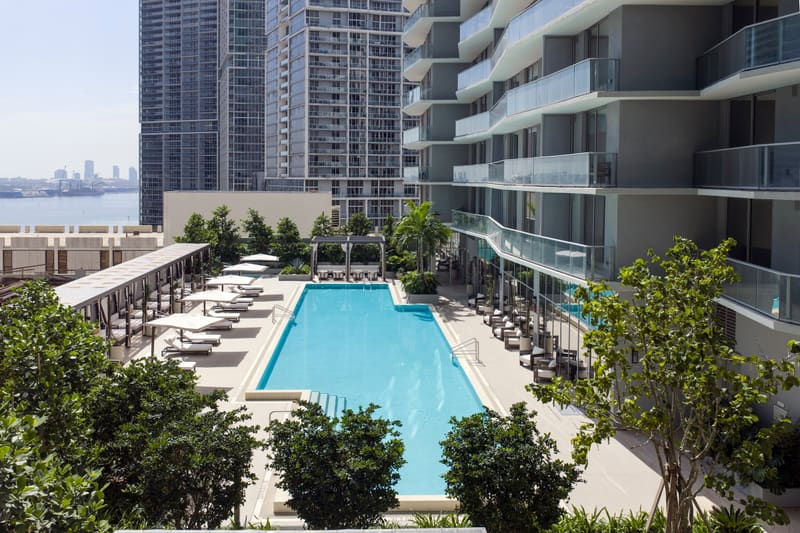 Pool deck with loungers and a view toward Biscayne Bay